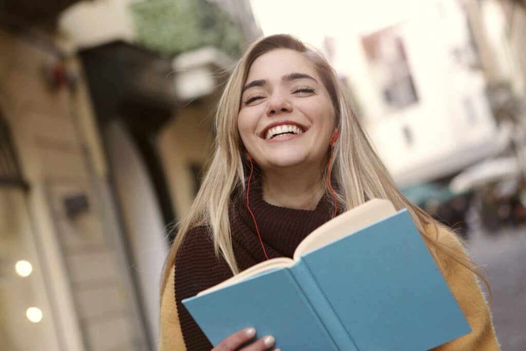 Photo by Andrea Piacquadio: https://www.pexels.com/photo/smiling-woman-in-black-and-yellow-long-sleeve-shirt-holding-blue-book-3781529/